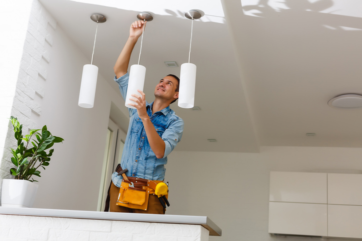 Electrician Fixing Light On Ceiling